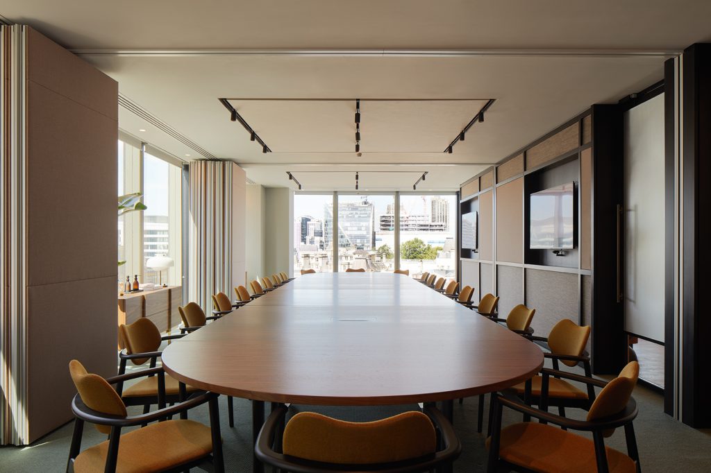 A large meeting room table with plenty of seats in the middle of a room with natural light at Myo's Liverpool Street office.