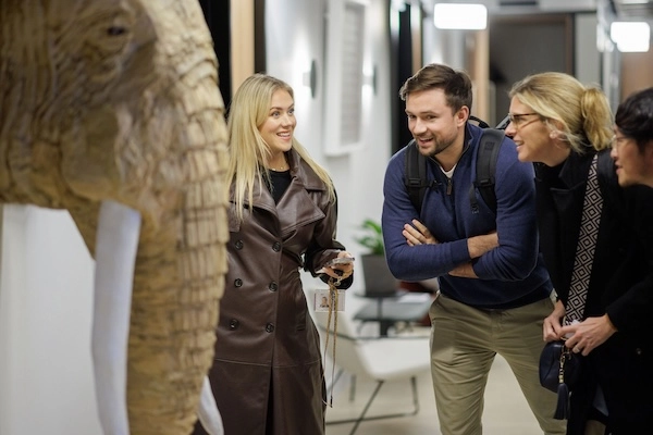 Employees gather round to discuss art at an office event.