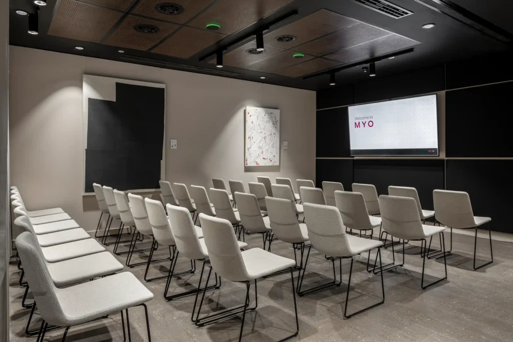 Rows of chairs facing a screen in an event space at MYO Bankside.