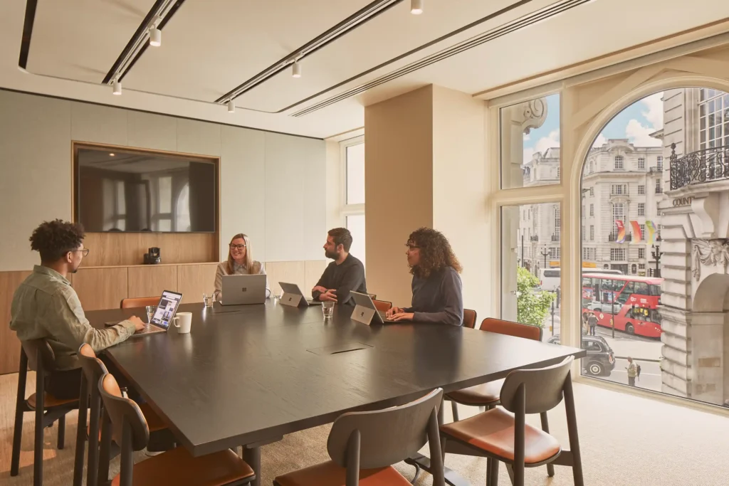 Professionals sit around a table with laptops at MYO Piccadilly.